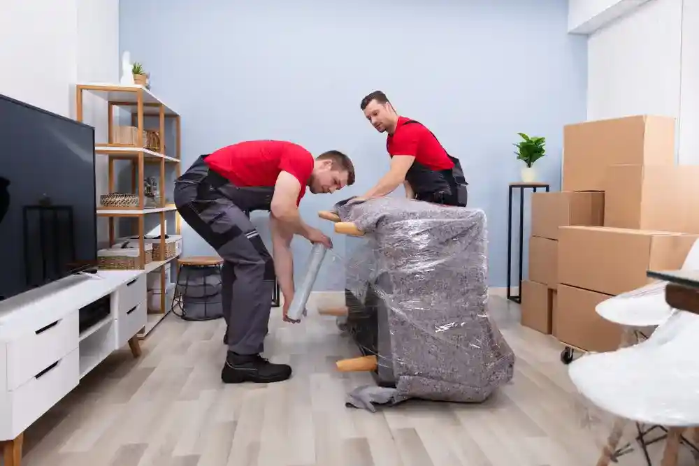 Professional movers unpacking and arranging furniture in a new home.
